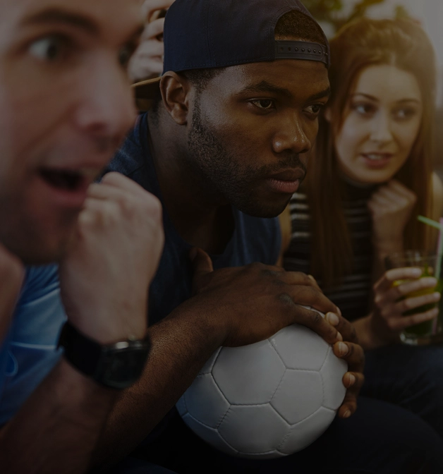 Adeptos de futebol a seguir um jogo ao vivo, destacando comunidades desportivas, experiências de visualização de jogos e envolvimento dos fãs.