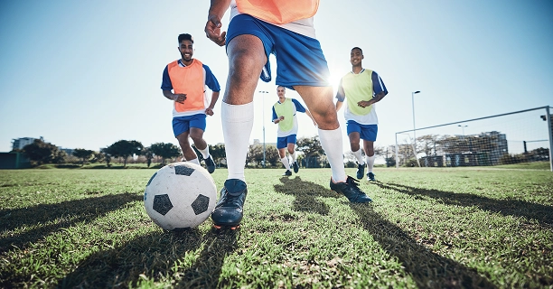 Uma equipa de futebol a praticar trabalho de equipa, movimentação e controlo de bola em preparação para jogos futuros.